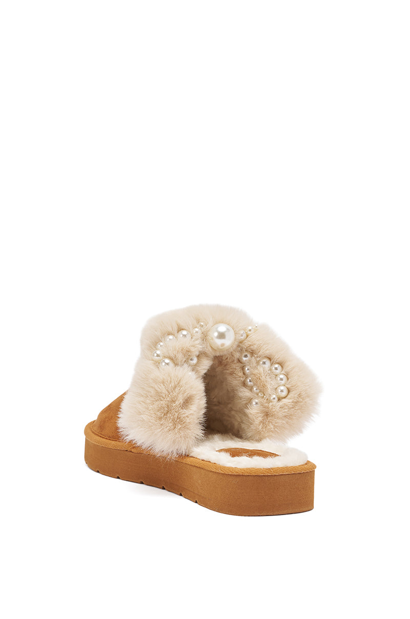 The AKIRA BOONE CAMEL SLIPPER WITH PEARLS features a tan flatform sole, fluffy beige fur trim, and decorative pearls. Shown from the back on a white background. 6