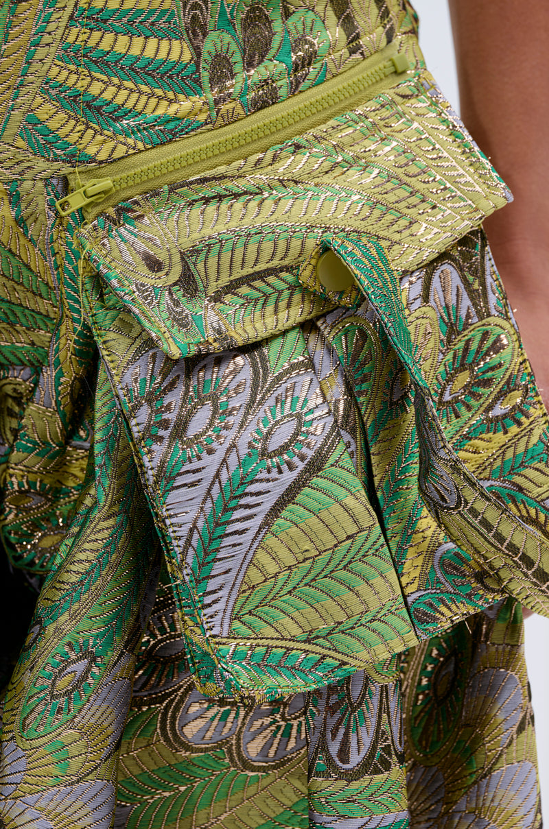 A green and gold embroidered belt bag with leafy patterns and zipper accents pairs boldly with metallic PEACOCK TROUSER wide-leg pants for a statement AKIRA Label look.