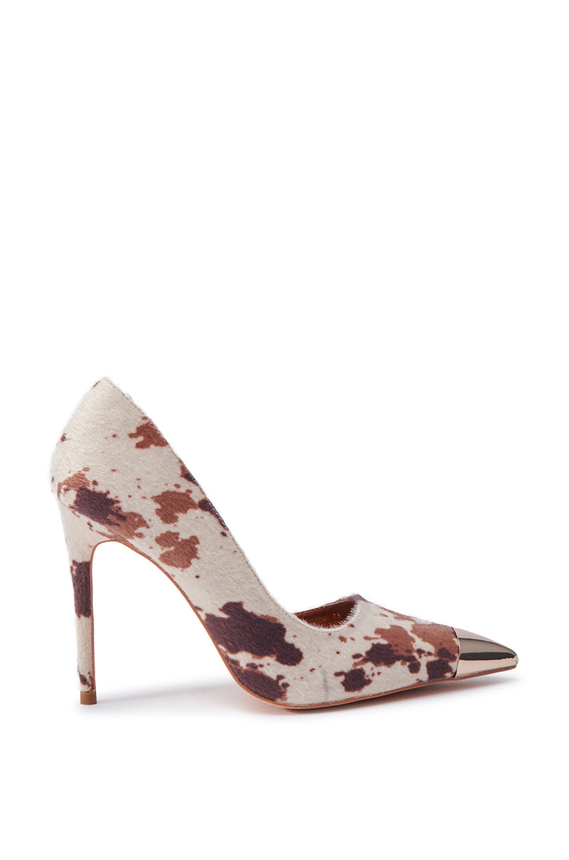 Introducing the AZALEA WANG BRAYAN COW STILETTO PUMP, a chic shoe adorned with a captivating brown and white cow print design, complete with a metallic pointed toe. The side view elegantly highlights its high heel, crafted from faux pony hair for enhanced texture and appeal.