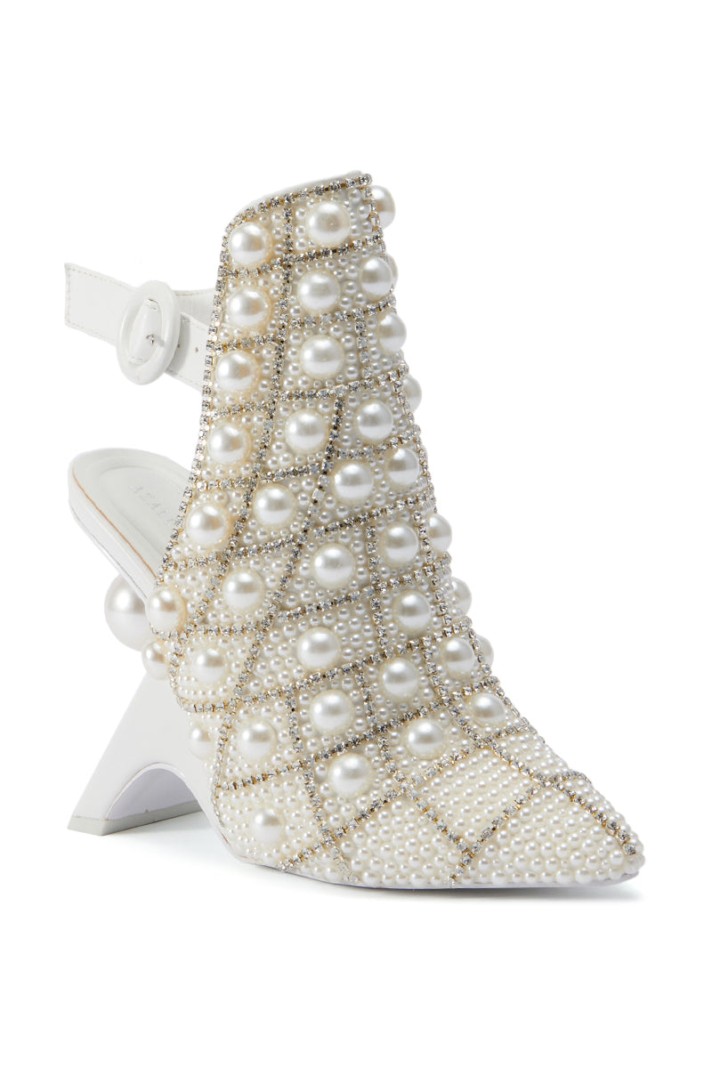 The AZALEA WANG BREAN EMBELLISHED PUMP is a white high-heeled shoe adorned with numerous pearls and small beads arranged in a crisscross pattern, boasting a unique, abstract inverted wedge heel and a white strap around the ankle.