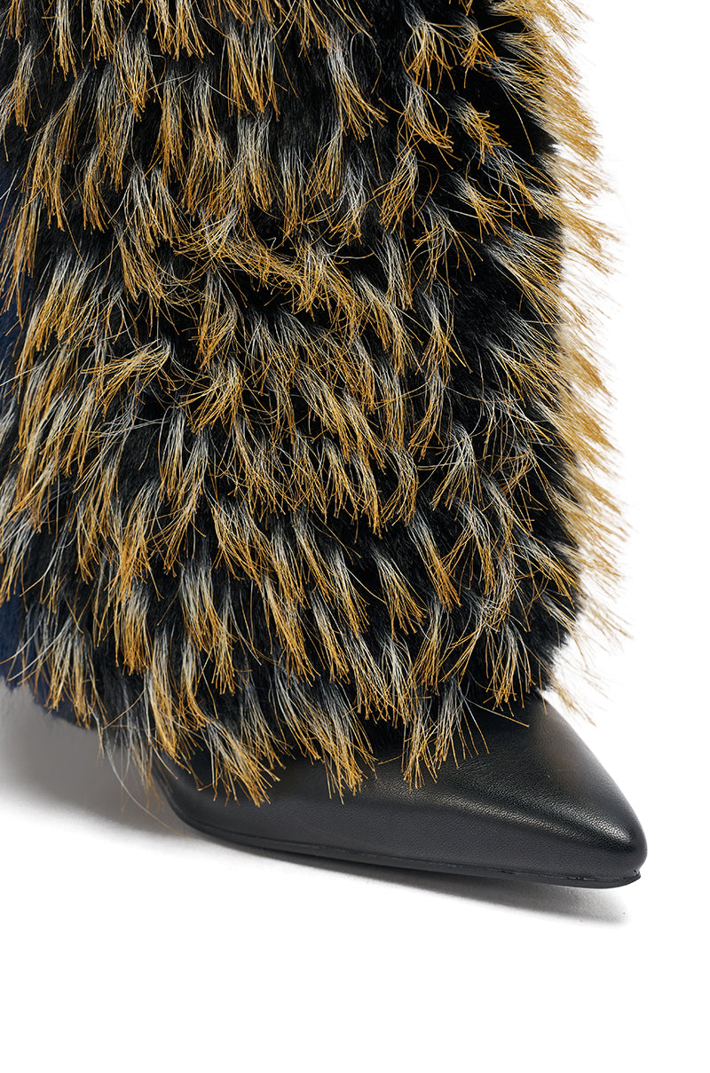 A close-up of the AZALEA WANG BRIASH NAVY MULTI WEDGE BOOTIE—a pointed-toe wedge bootie adorned with thick, shaggy fur in rich black and brown hues.