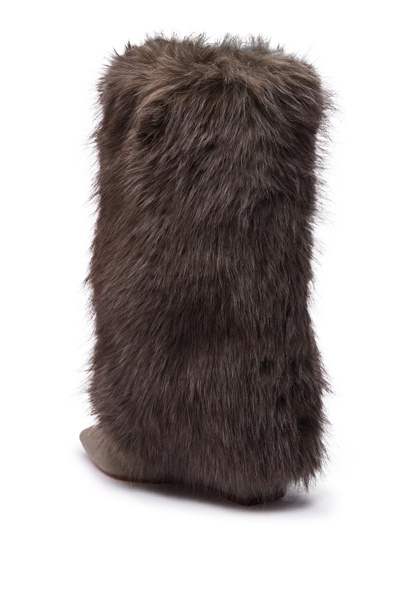 The AZALEA WANG BRIASH OLIVE WEDGE FUR BOOTIE is shown from the back and side, featuring long dark brown faux fur, a slightly pointed toe, and a flat sole, all set against a white background.