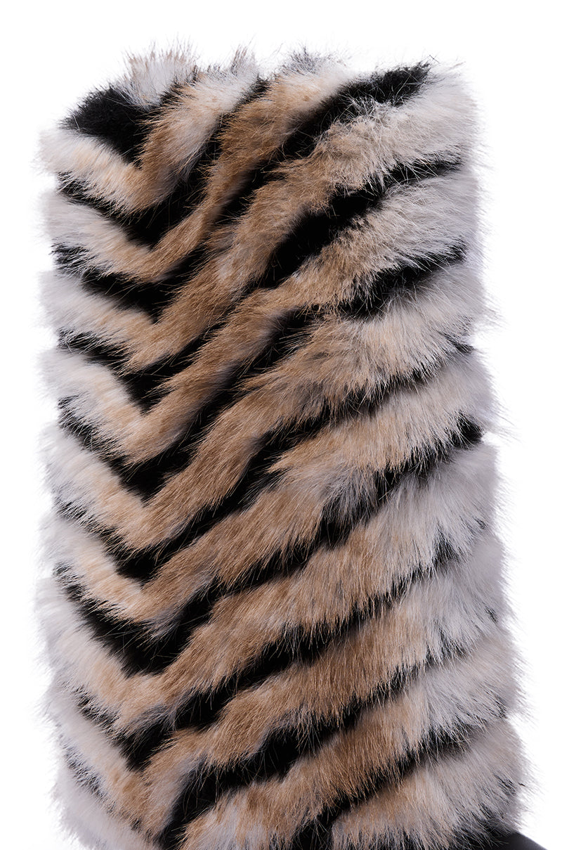 A close-up of the AZALEA WANG BRIENNE BLACK FUR HIDDEN WEDGE BOOTIE, featuring a chevron pattern in tan, black, and white faux fur that mimics animal fur with zigzag stripes.
