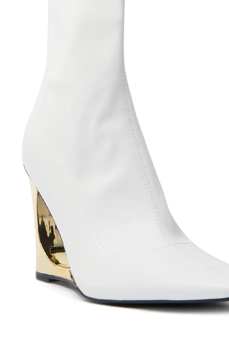 The AZALEA WANG BRIXHAM WHITE BOOTIE is a sleek, white ankle boot featuring a unique gold novelty heel, smooth stitching, and an elegant modern look, crafted from vegan leather.