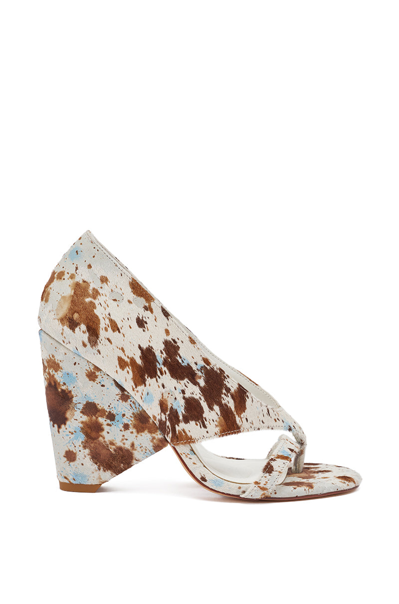 The AKIRA GOLD BRONNIE COW CHUNKY THONG SANDAL is a chic western-style high-heel sandal with an open toe, wide angled heel, and brown and white genuine calf hair cow print pattern. 5