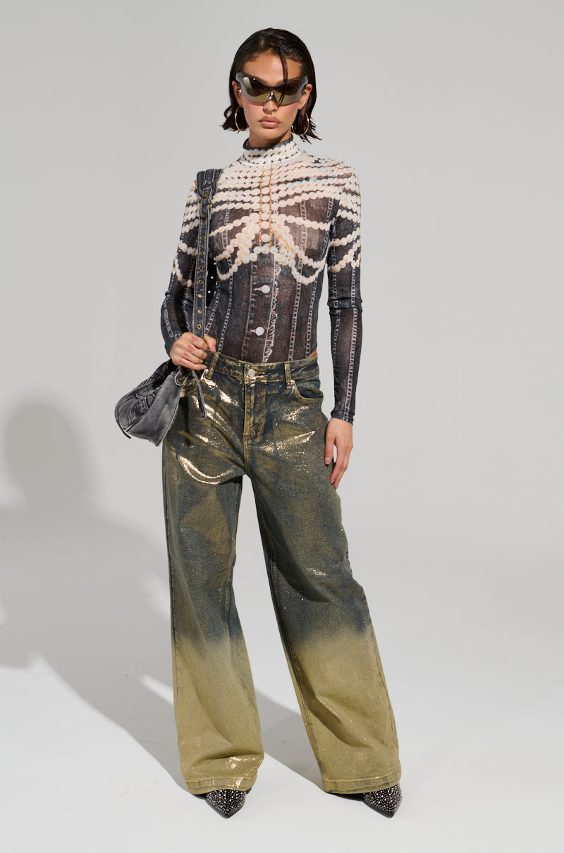 Wearing the LOCKED IN BODYSUIT alongside sheer mesh futuristic sunglasses and metallic ombré wide-leg pants, a person exudes confidence while holding a textured handbag. They pose against a plain background.