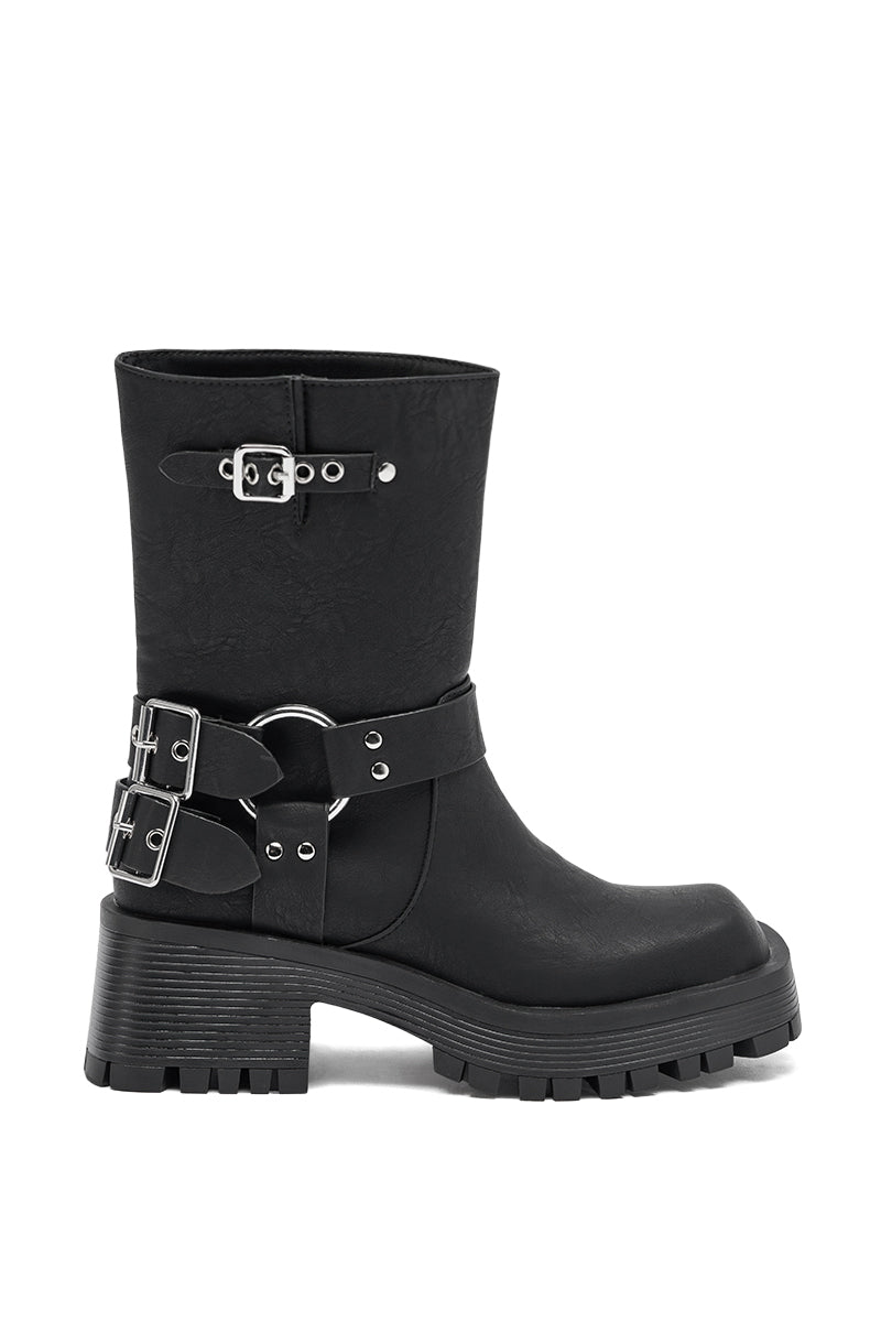 The AZALEA WANG BUCKED BLACK CHUNKY HEEL COMBAT BOOTIE features black faux leather, a chunky sole, mid-calf height, and three silver-buckled straps—two at the ankle and one near the top—for a bold, stylish look.