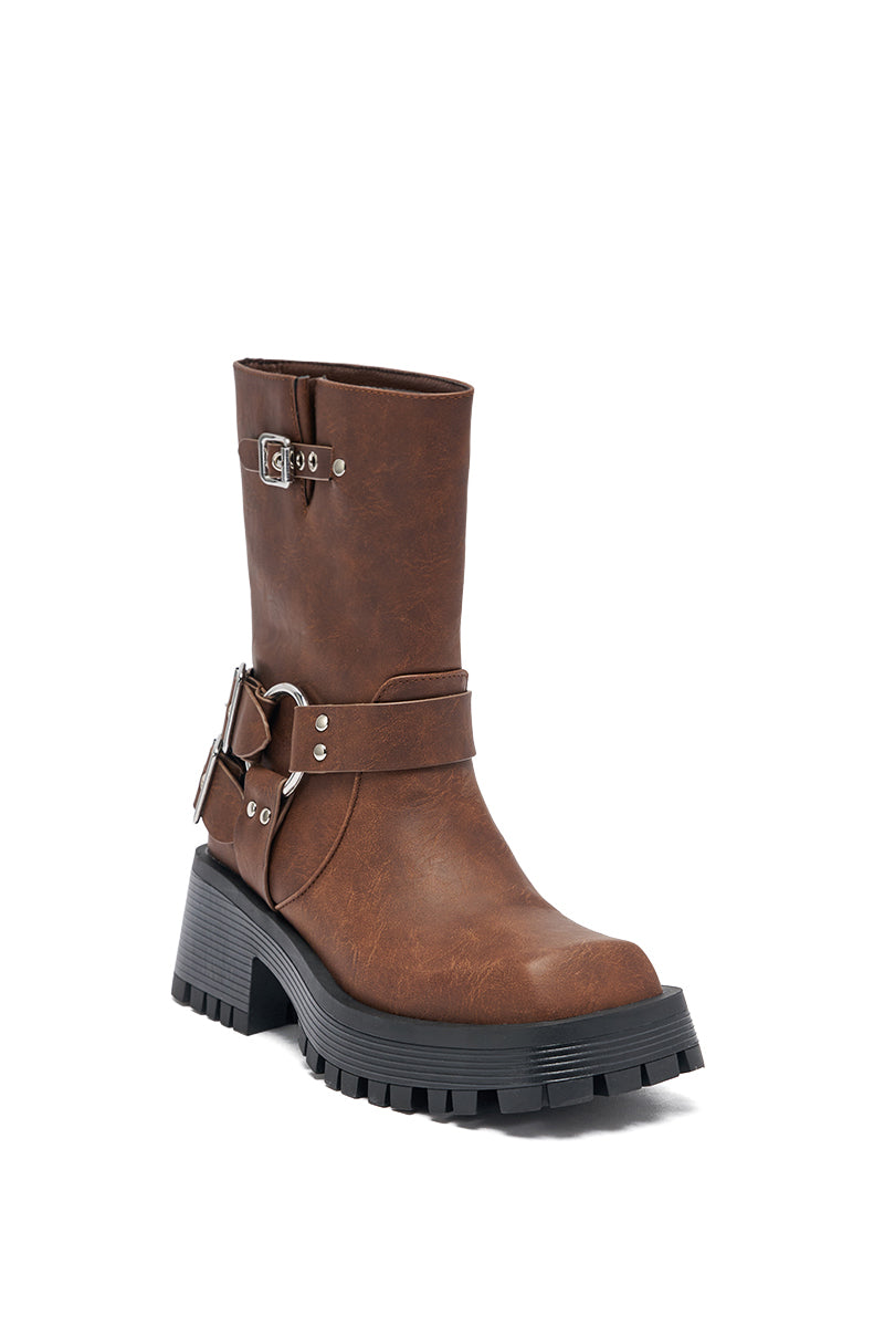 The AZALEA WANG BUCKED BROWN CHUNKY HEEL COMBAT BOOTIE features brown faux leather, a chunky black sole, decorative straps with silver buckles, and a rugged tread, displayed against a white background. 6