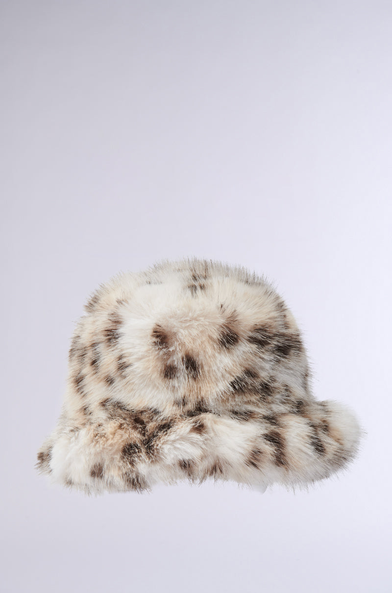 Introducing the LEO BABE FAUX FUR BUCKET HAT, featuring a plush faux fur design with a chic cream and dark brown spotted pattern reminiscent of cheetah print on a light gray backdrop. 2