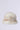 The TOASTIE FAUX FUR BUCKET HAT is a stylish accessory featuring a fluffy, soft texture in white and light brown against a simple gray backdrop. This cozy hat exudes warmth, making it perfect for chilly weather.