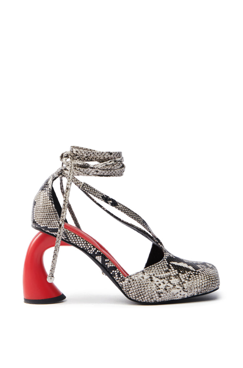 The AZALEA WANG BUIKY pump is a high-heeled shoe with faux snakeskin, crisscross ankle straps, and a striking red curved heel set against a plain white background.