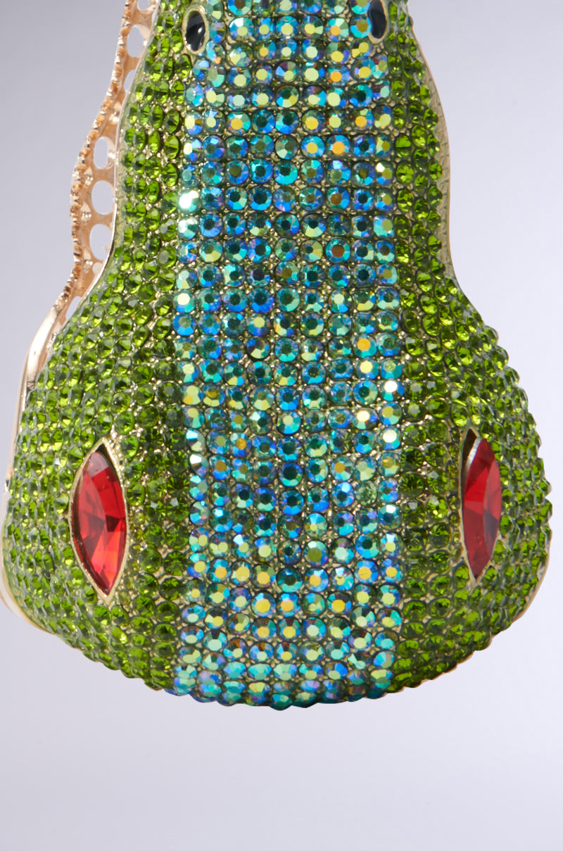 Introducing the BITE ME CUFF BRACELET: a dazzling crocodile-shaped accessory adorned with multicolored rhinestones and accented by red gems, forming an intricate design. The bracelet features a metallic frame that enhances its luxurious and captivating appeal. 4