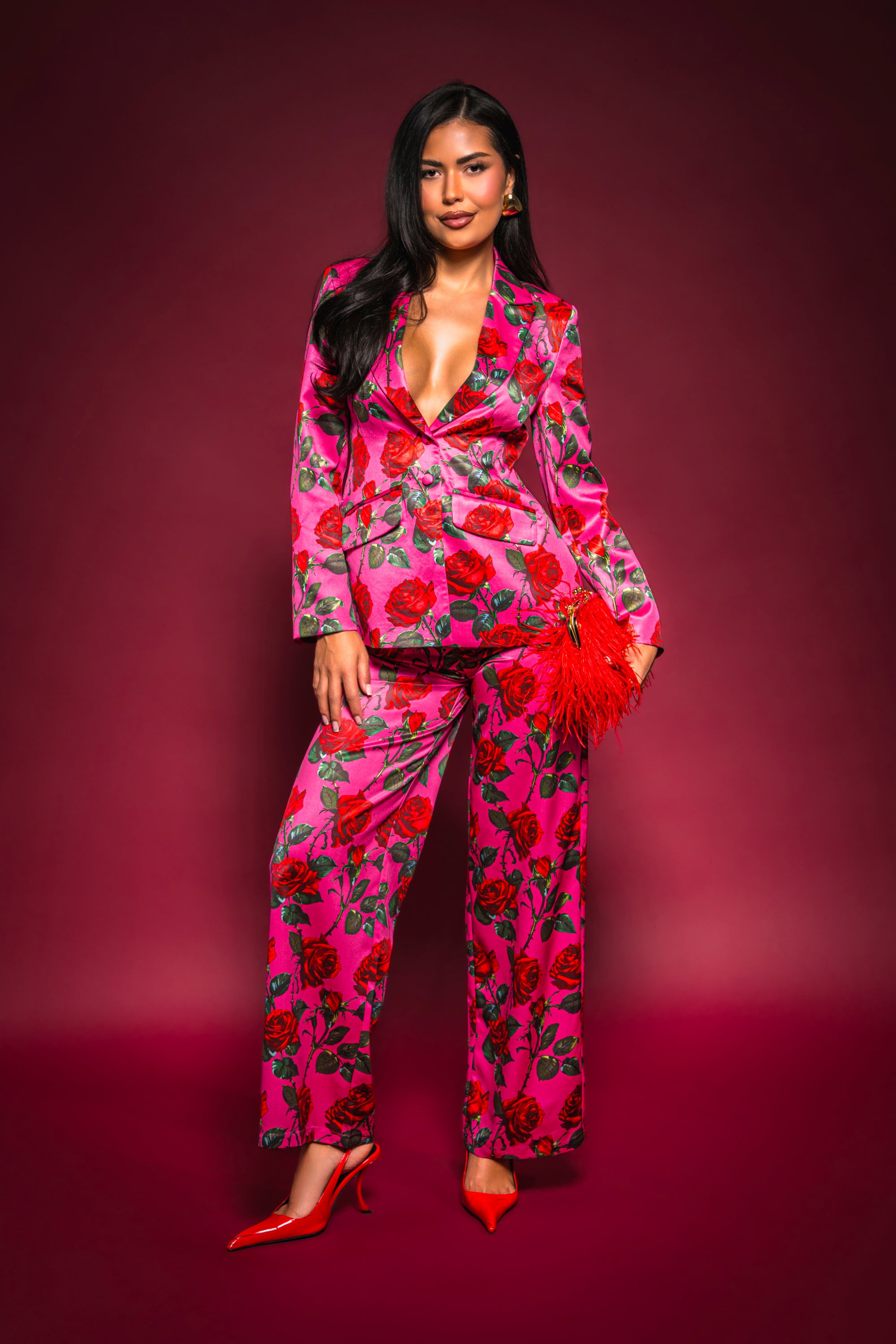 A woman in a pink suit featuring the DOZEN ROSES SATIN PANT IN FUCHSIA. 0