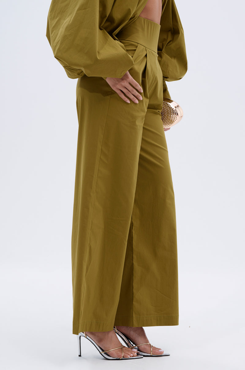 A person wearing the GOLD COAST WIDE LEG PALAZZO PANT and a matching wide-sleeve top, accessorized with a gold clutch and silver high-heeled sandals, stands against a plain white background. 3