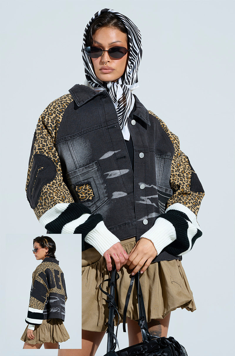 A person dons a chic outfit with a FIERCE CHEETAH BOMBER JACKET, paired with a zebra-patterned scarf, sunglasses, khaki skirt, and holds a black bag against a plain background. The image includes an inset showing the jacket's back view.
