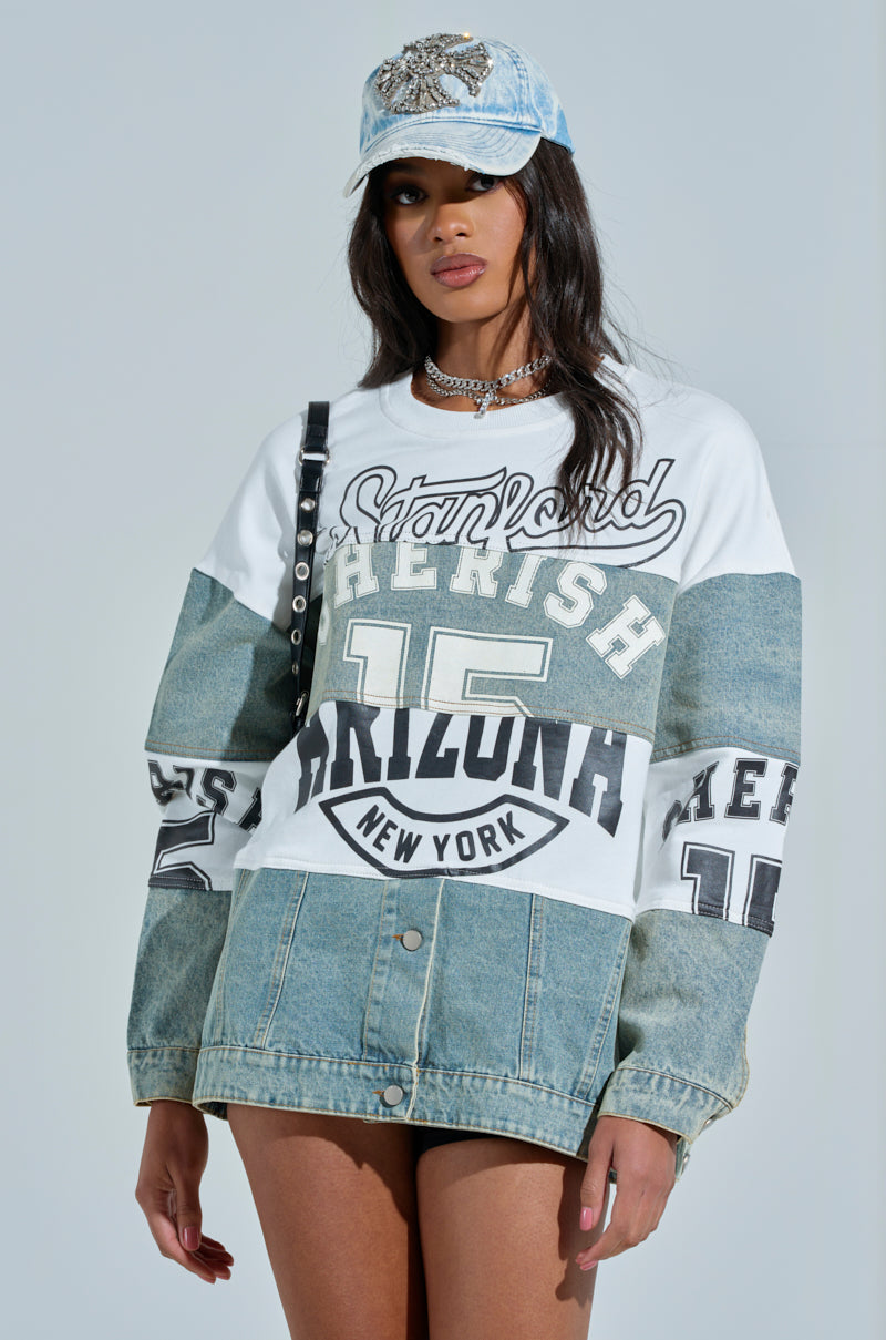 A person in a KEEP IT COOL DENIM MINI DRESS, wearing a denim baseball cap and an academia long-sleeve shirt with graphics like "Stanford," "15," and "Arizona New York." The shirt features color block denim patchwork on the sleeves, accessorized by a choker necklace. 2