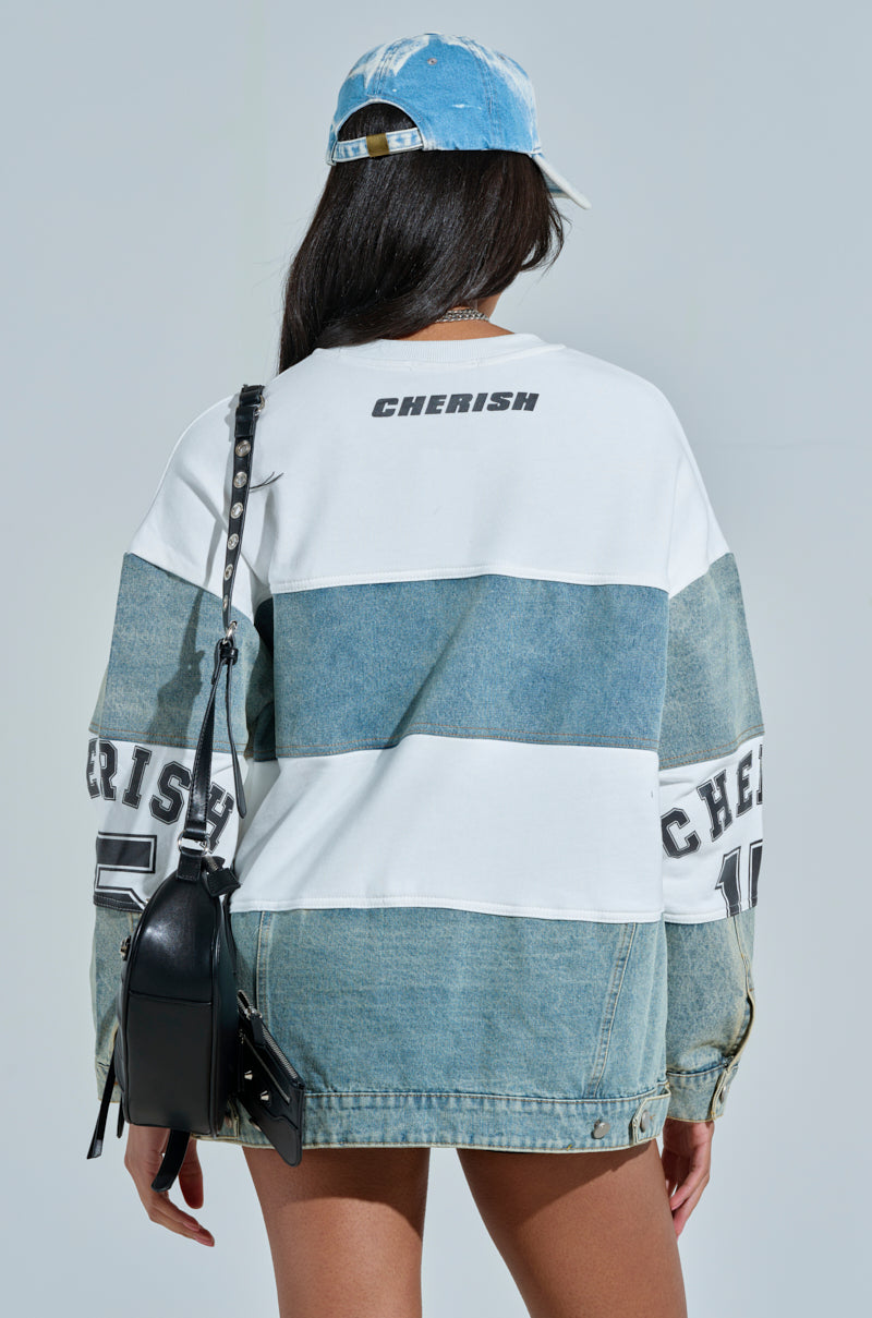 Against a plain backdrop, someone wears an academia-inspired color-blocked jacket with "CHEERISH" on the back and sleeves. Styled with a denim cap and black crossbody bag, the light denim and white sections of this chic piece make a statement. Product: KEEP IT COOL DENIM MINI DRESS. 5