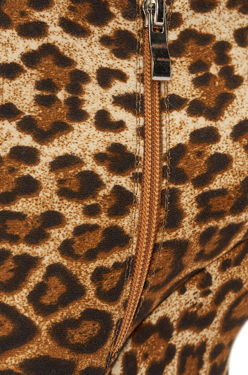 Close-up of leopard print fabric with a brown zipper and silver pull, similar to the bold pattern featured on the AZALEA WANG CADY LEOPARD PRINT WEDGE BOOTIE with ankle zip closure. 6