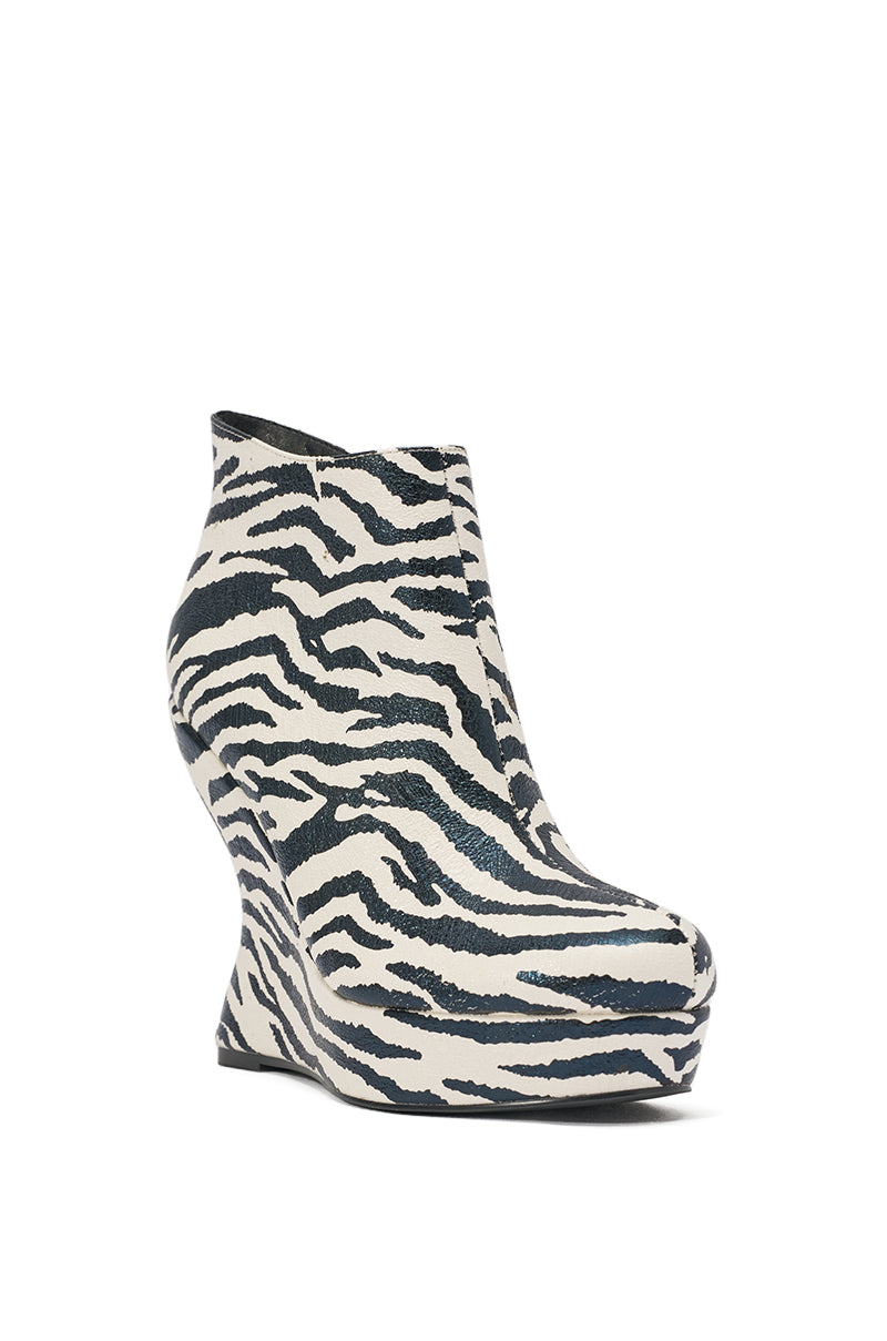 The AZALEA WANG ZEBRA PU PRINT WEDGE BOOTIE features a bold black and white zebra print in faux leather, with a platform wedge, rounded toe, and sculpted heel. 3