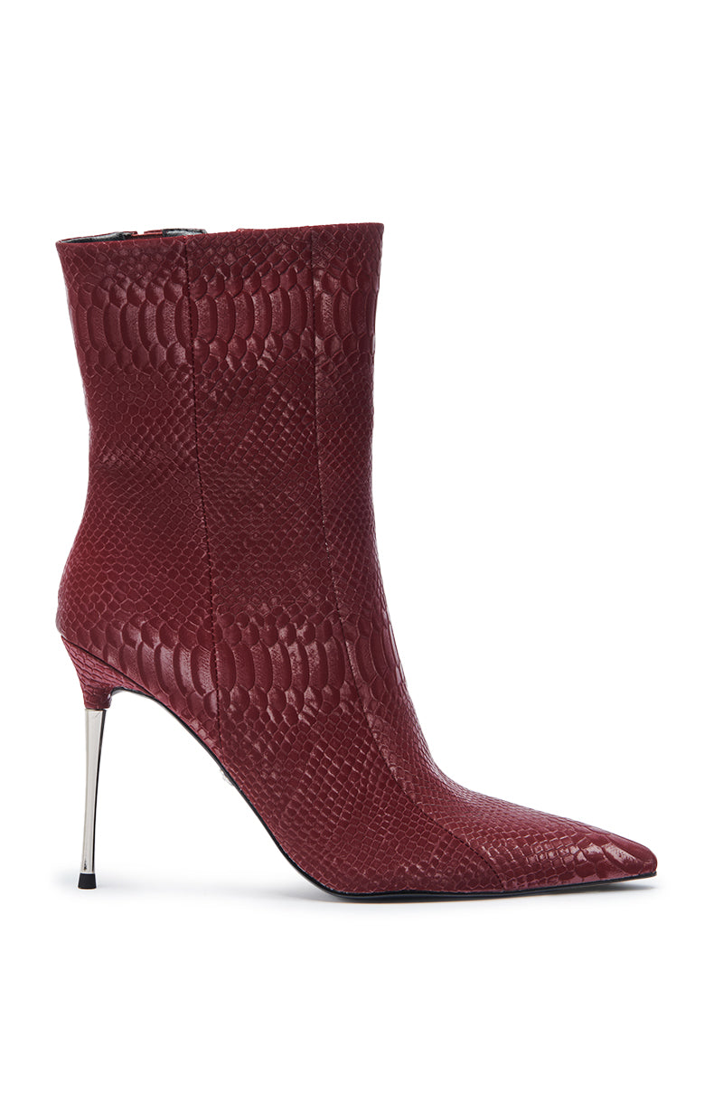 The AZALEA WANG CALEAN BURGUNDY BOOTIE features a pointed toe, bold snakeskin pattern, and a high, slim metal stiletto heel for a striking statement look.