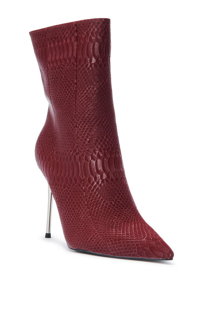 The AZALEA WANG CALEAN BURGUNDY BOOTIE features a bold snakeskin pattern, pointed toe, and high stiletto heel for eye-catching sophistication.