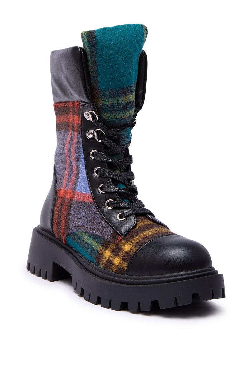 The AZALEA WANG CALIBAN BLACK MULTI PLAID COMBAT BOOTIE features a chunky lug sole, black faux leather toe and heel, multicolored plaid panels in green, blue, red, and yellow tones, with black laces and metal eyelets.