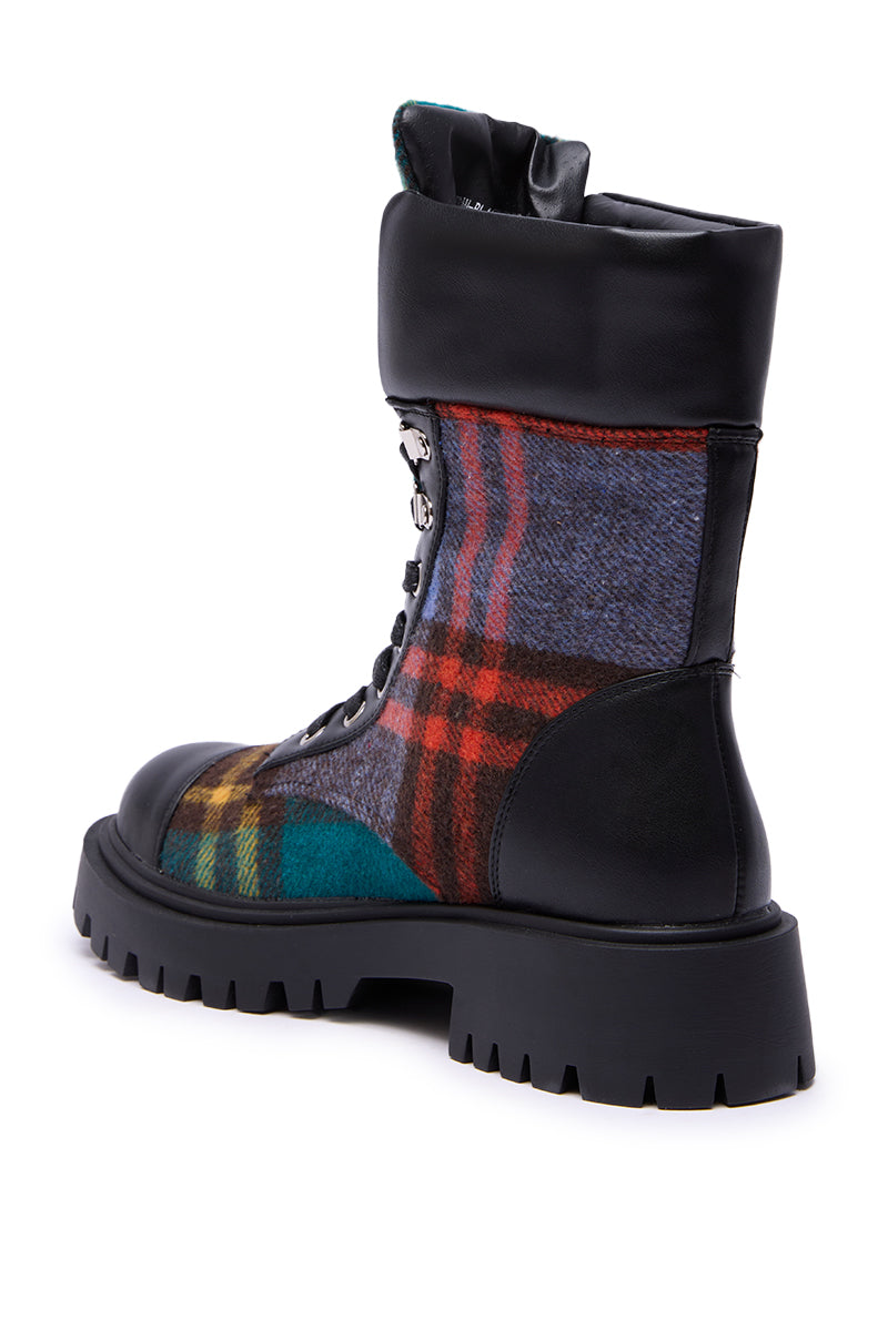 The AZALEA WANG CALIBAN BLACK MULTI PLAID COMBAT BOOTIE features a chunky lug sole, black faux leather accents, multicolored plaid fabric in red, blue, green, and yellow, lace-up details, and a fold-over top for a bold look.