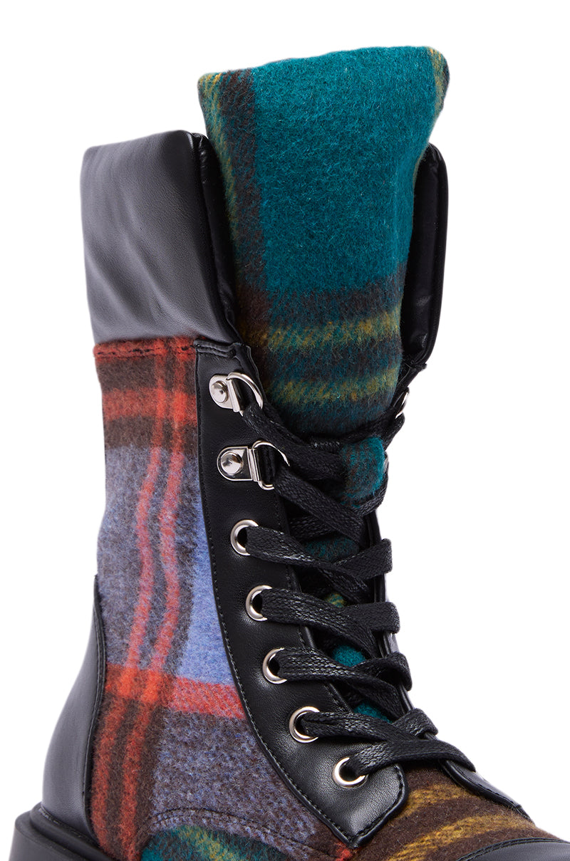 The AZALEA WANG CALIBAN BLACK MULTI PLAID COMBAT BOOTIE features a close-up of colorful blue, green, red, and yellow plaid wool with black faux leather, black laces, silver eyelets, and a chunky lug sole for edgy style.