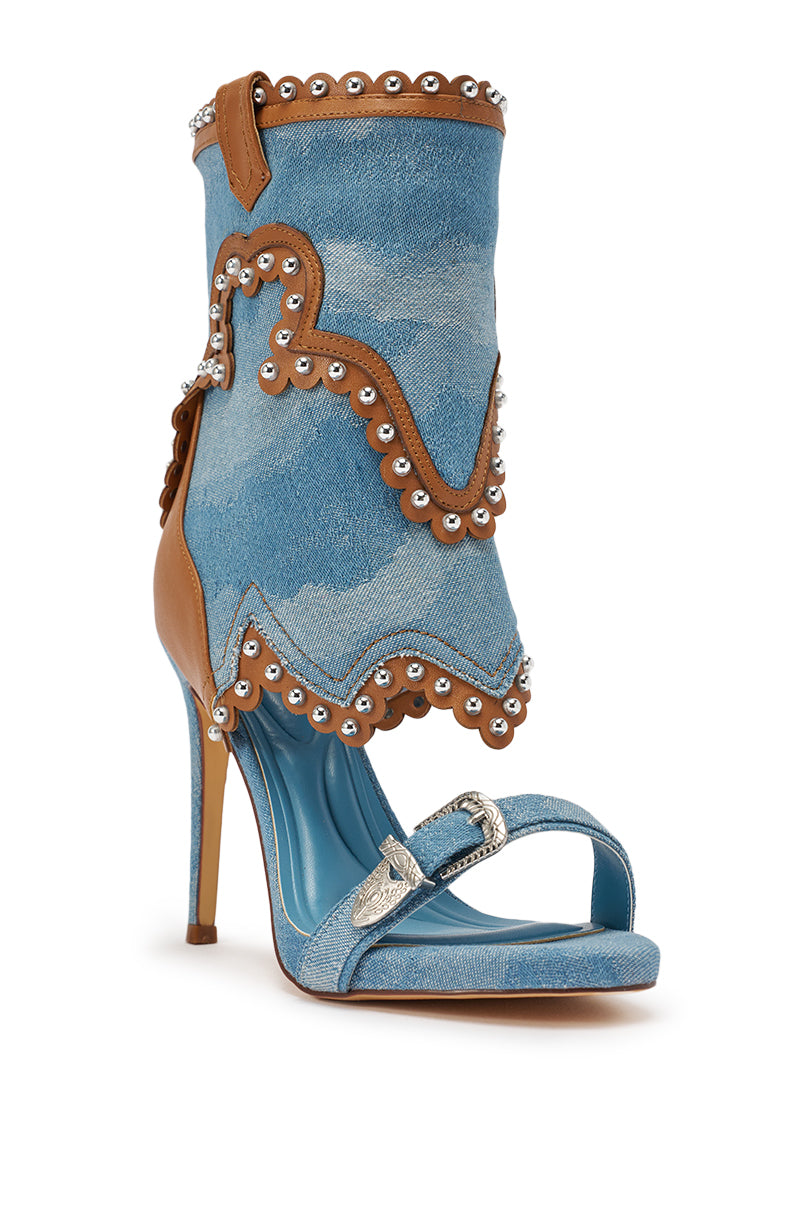 The AZALEA WANG CAPRIZIA DENIM WESTERN NOVELTY STUDDED STILETTO SANDAL features a denim upper, tan leather trim, silver studs, scalloped details, an open toe, a buckled front strap, and a tall stiletto heel. 5