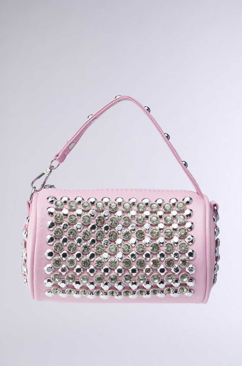 The LUXE LIFESTYLE PURSE features a pink finish, short handle, and rows of large silver studs on the front and sides. This chic crossbody bag adds instant glam to any outfit, shown here against a plain light background.
