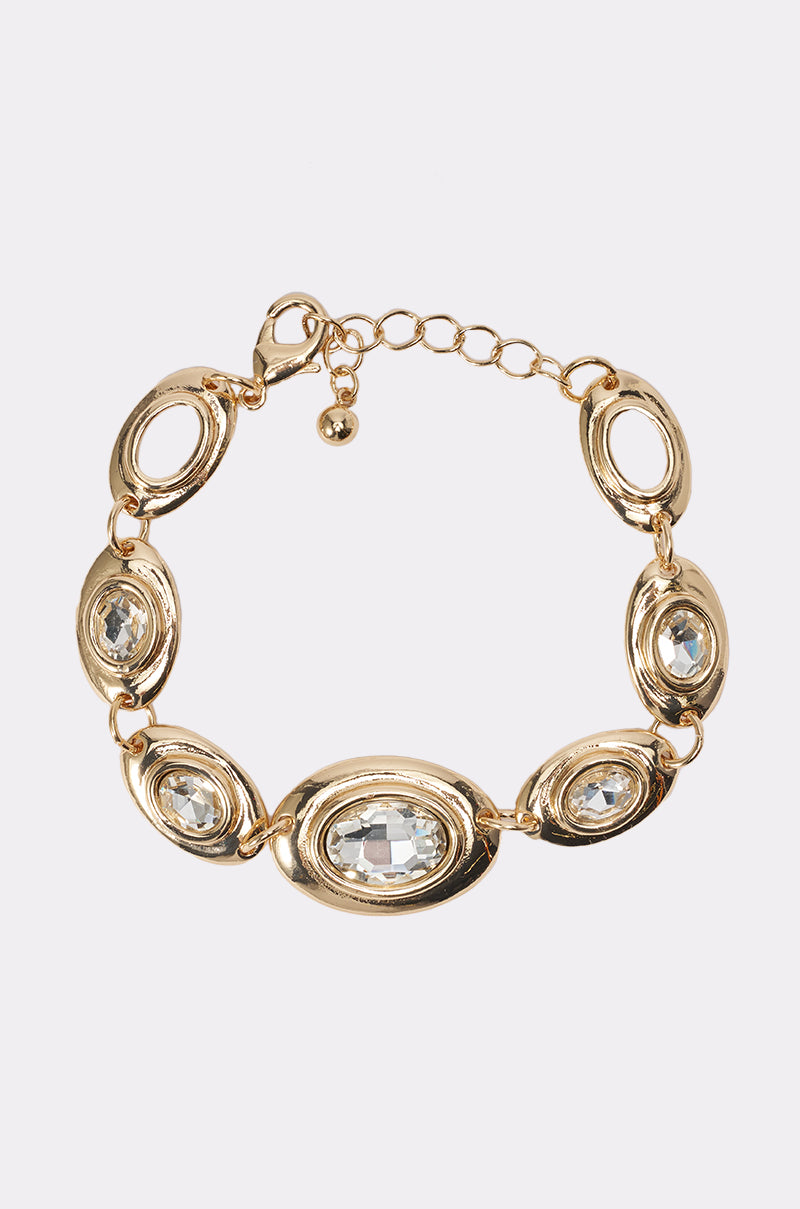 The RUNWAY READY BRACELET IN GOLD features oval links set with clear gemstones, an adjustable chain, and a lobster clasp closure. 0