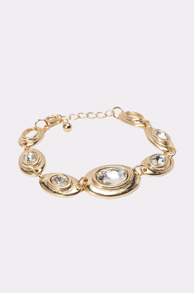 The RUNWAY READY BRACELET IN GOLD features oval and round links, each with a clear gemstone at the center—a bold statement accessory shown on a white background. 2
