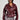 A woman wears the TEDDI MOTO, a shiny, deep red faux leather jacket featuring a belted waist, elegantly paired with a fringed skirt. Her short black hair enhances the look of her large, dark sunglasses against a plain light-colored background.