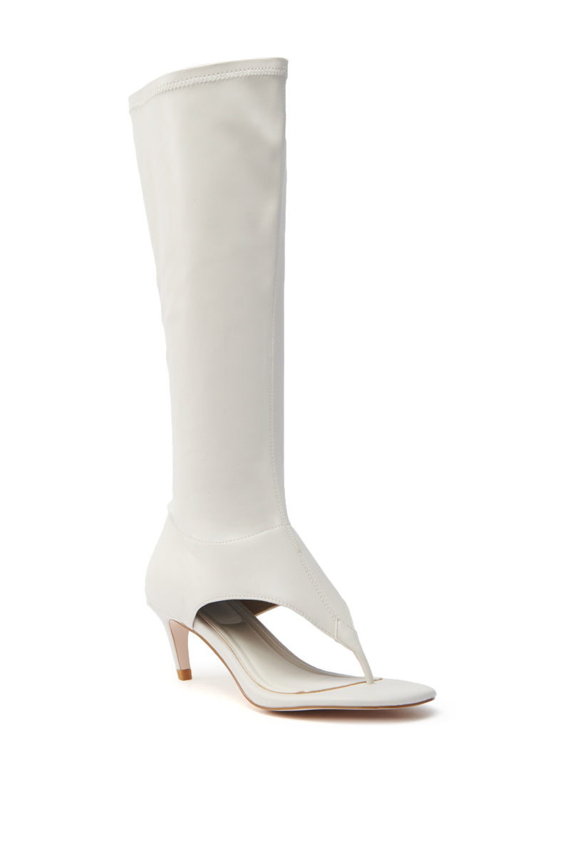 The AZALEA WANG CECILE BONE SANDAL STILETTO is a white knee-high, open-toe boot made from vegan leather, featuring an almond thong toe, elegant ankle-to-foot cut-out design, and a chic short stiletto heel.