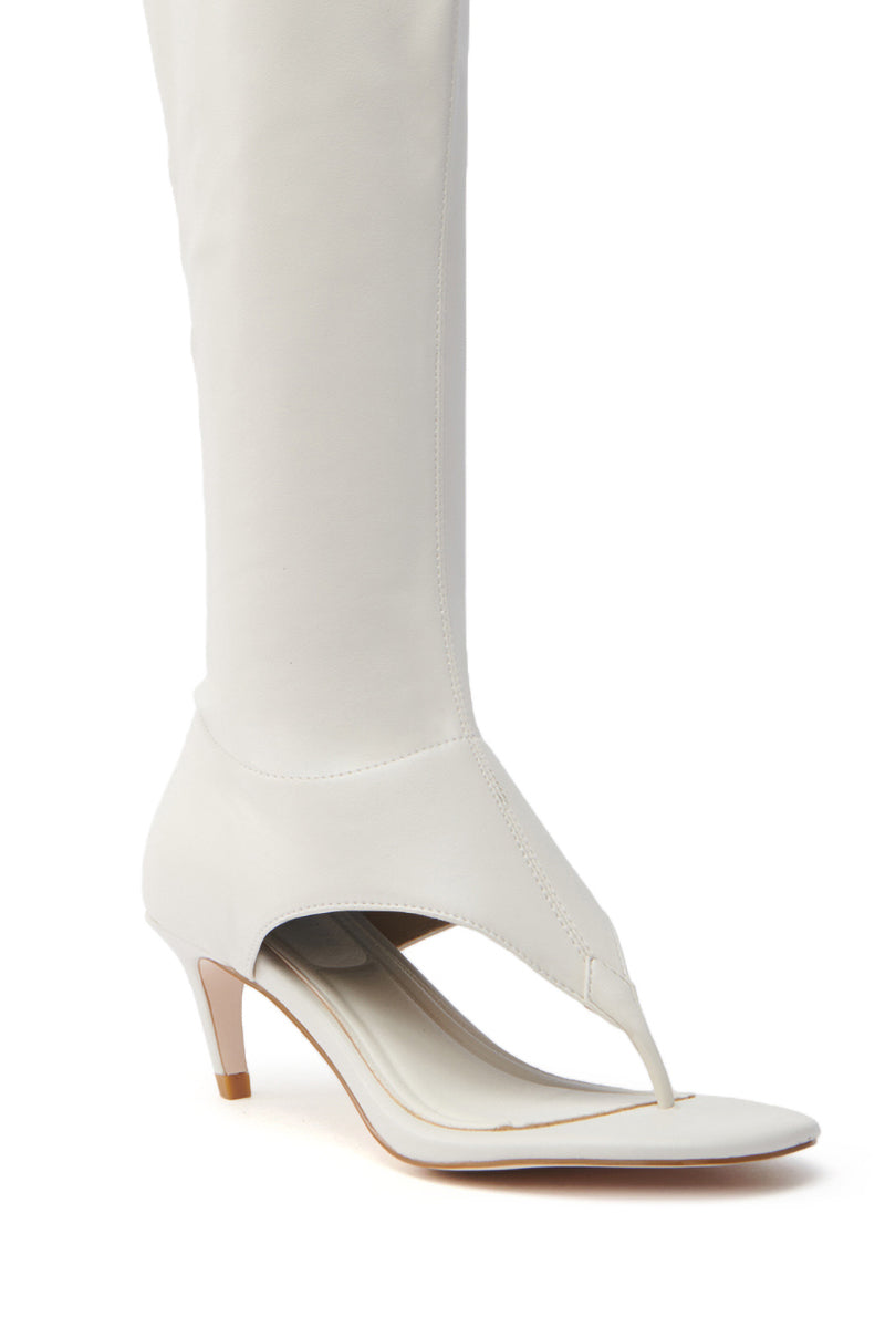 The AZALEA WANG CECILE BONE SANDAL STILETTO is a white vegan leather high-heeled boot with open toes, featuring a stiletto heel and an almond thong toe design. Its sleek, smooth material extends up the leg for a seamless, modern look that enhances sophistication.