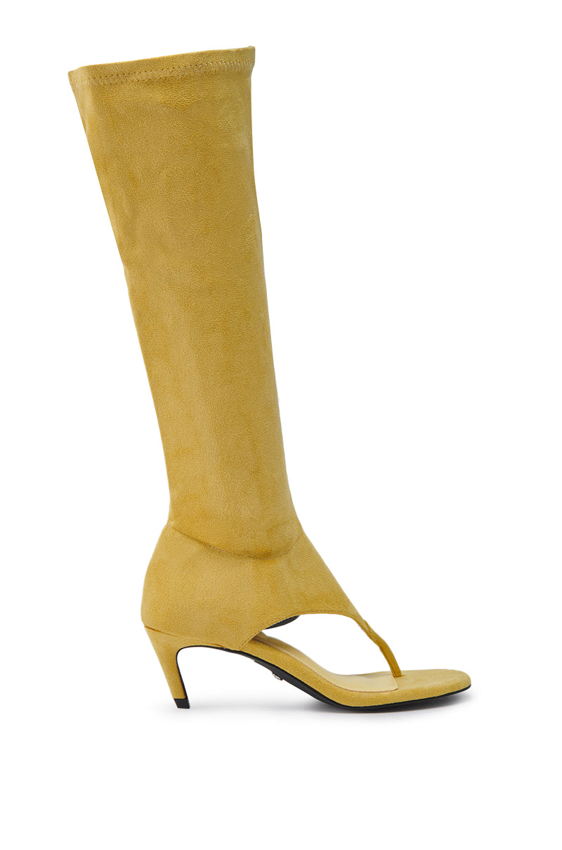The AZALEA WANG CECILE MUSTARD SANDAL STILETTO is a yellow faux suede, knee-high sandal with an open toe, thong design, short heel, and a stylish boot-sandal blend.
