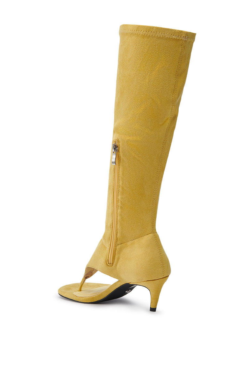 The AZALEA WANG CECILE MUSTARD SANDAL STILETTO is a chic faux suede, yellow knee-high boot featuring a unique thong front, side zipper, and low kitten heel—a stiletto-inspired style that stands out with a bold knee-high shaft.