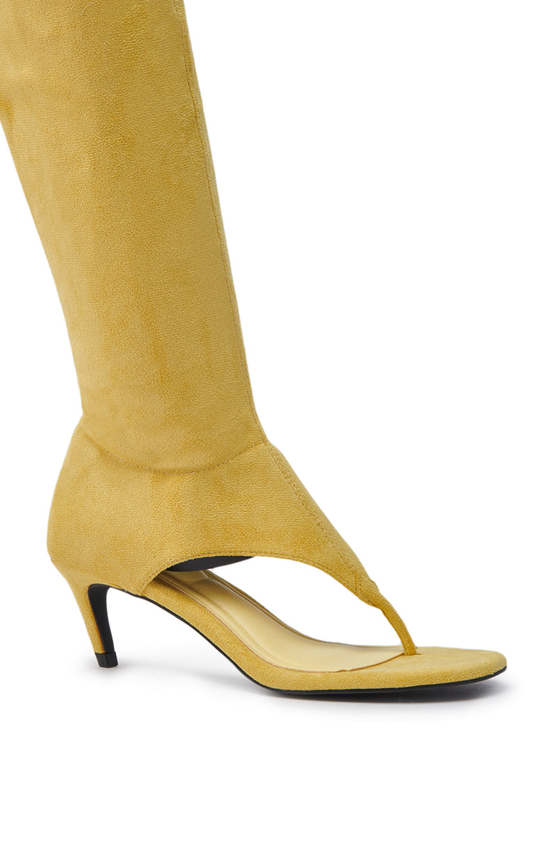 A close-up of the AZALEA WANG CECILE MUSTARD SANDAL STILETTO, a yellow faux suede, knee-high open-toe thong sandal that blends boot and sandal styles for a unique look.