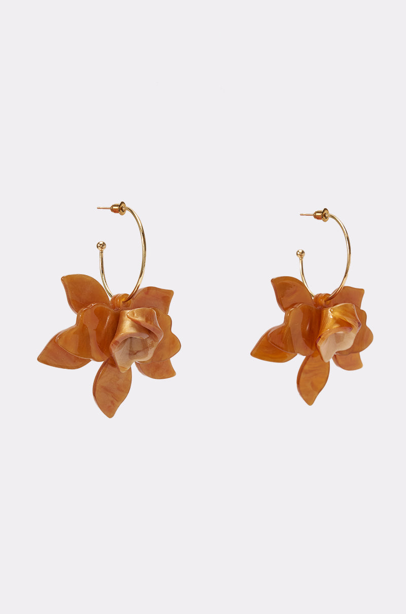 Introducing the GOLDEN HOUR PETAL EARRINGS—gold hoop earrings adorned with large, five-petal flower-shaped pendants in an orange-brown acrylic, perfect for making a statement with your summer jewelry. Shown against a plain white background.