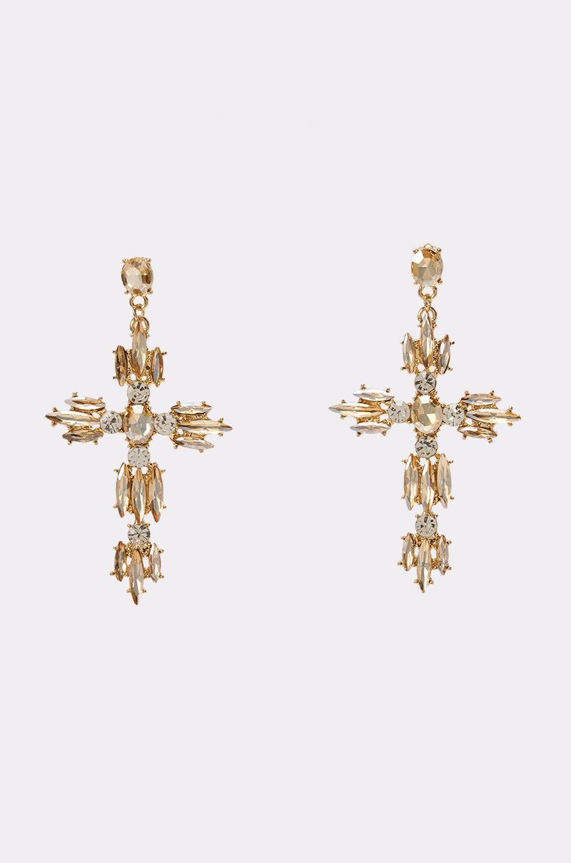 The GOLD RUSH CROSS EARRINGS are expertly crafted in a bold cross shape and adorned with numerous sparkling rhinestones, beautifully presented against a simple light background. These statement concert earrings perfectly combine elegance and striking style for an unforgettable look.