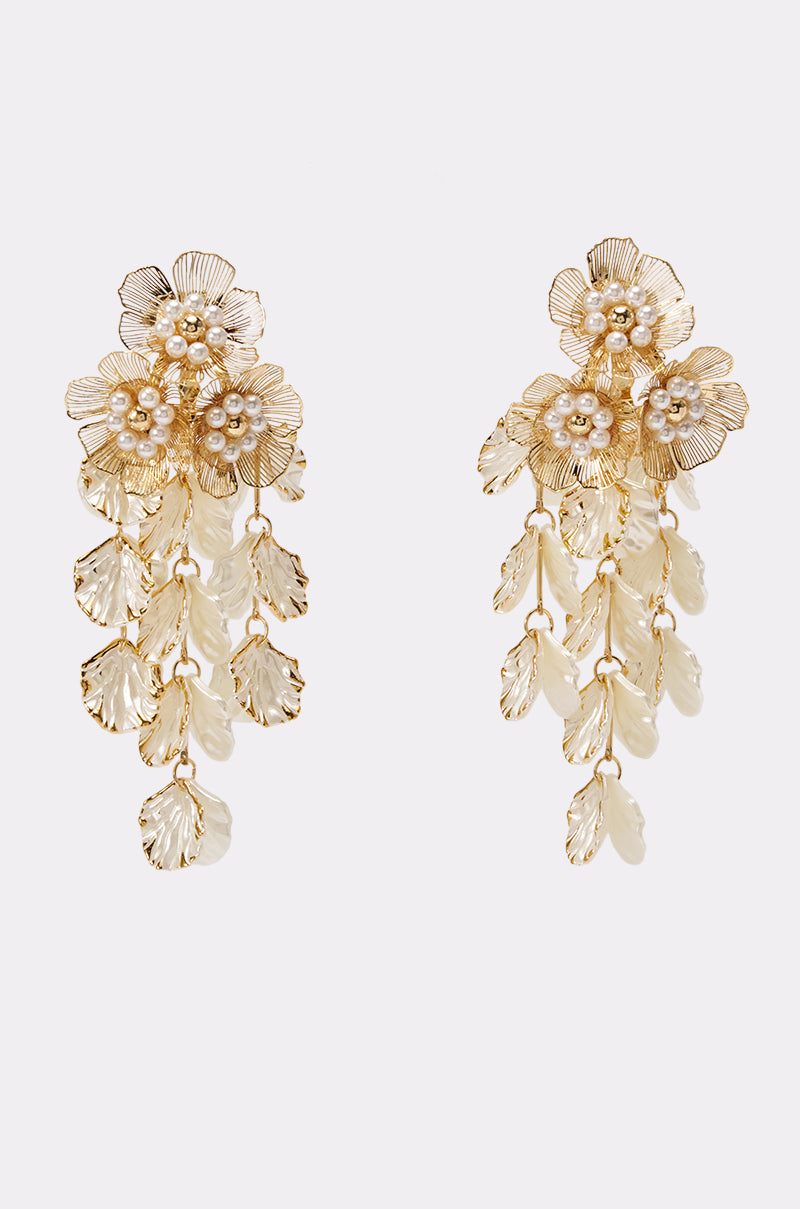 FLORAL PEARL STATEMENT EARRINGS feature gold floral designs with intricate petals, luminous pearl centers, and cascading leaf charms, making them the perfect wedding accessory. Elegantly showcased on a simple white background.