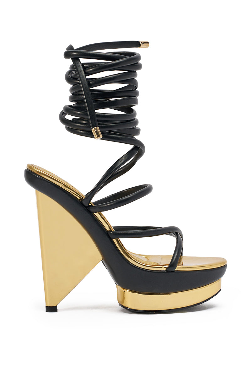 The AKIRA GOLD CELINEA BLACK NOVELTY GOLD HEEL SANDAL features a gold metallic heel and platform, crisscrossing black straps, and a long black ankle wrap that coils up the leg for a standout high-fashion look. 4