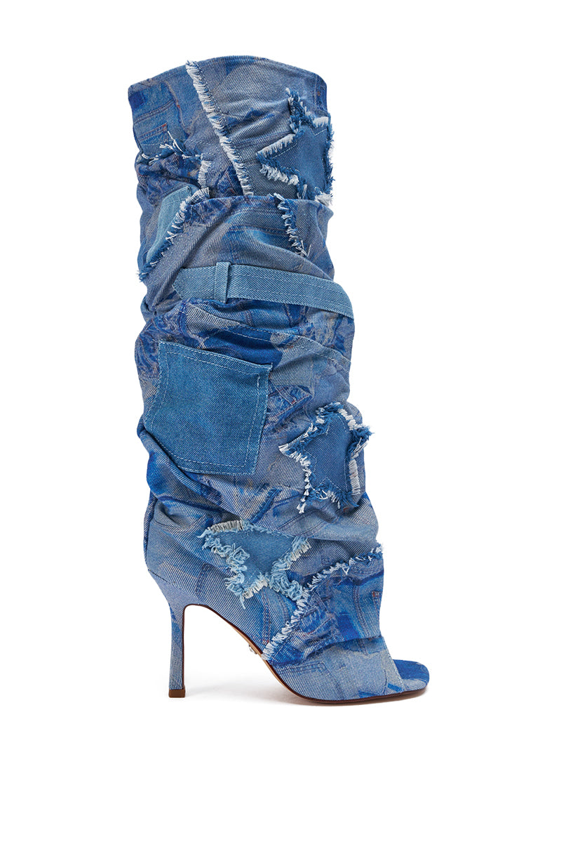 The AZALEA WANG CHAITRA DENIM OPEN TOE BOOT is a knee-high slouch boot in distressed blue denim with frayed edges, patchwork, a pocket accent, and an open toe on a sleek stiletto heel.
