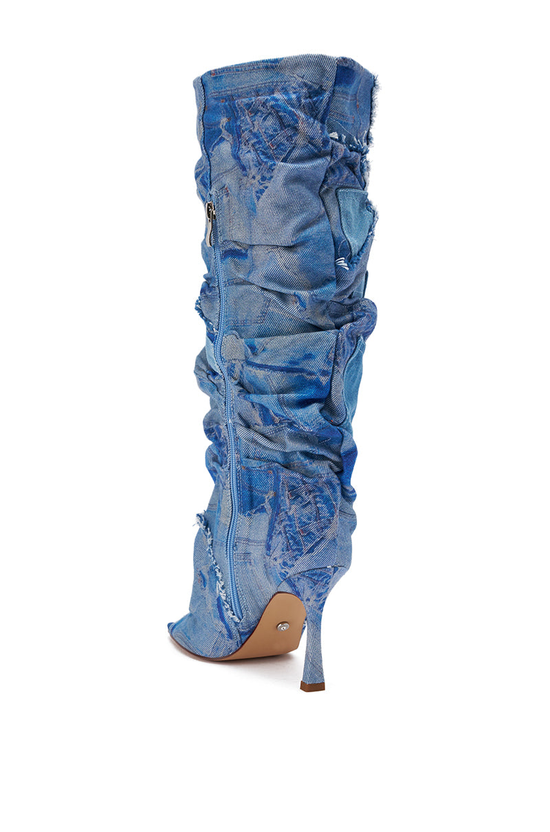 The AZALEA WANG CHAITRA DENIM OPEN TOE BOOT features distressed blue denim, an open toe, slouchy ruched design, a visible side zipper, and a pointed stiletto heel—ideal for fans of bold patchwork-inspired footwear.