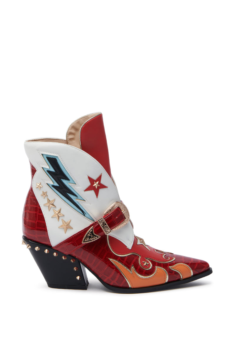 The AZALEA WANG CHANNING MULTI WESTERN BOOTIE is a red leather ankle boot with a chunky heel, featuring colorful designs, white sections with star and lightning bolt motifs, orange flames, and metal studs along the heel—ideal for adding a Western Bootie flair.