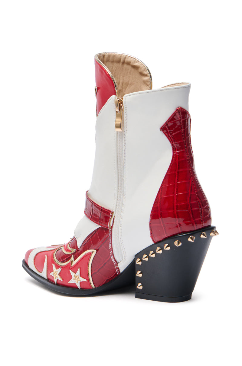 The AZALEA WANG CHANNY MULTI BOOTIE is a stylish mid-calf bootie in red and white faux leather with star and flame patterns, a pointed toe, black chunky heel with metallic studs, and convenient side zipper.