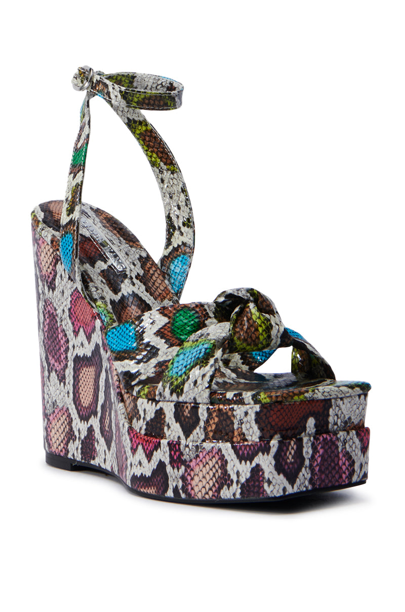 The AZALEA WANG CHARMANDER MULTISNAKE WEDGE SANDAL features a vibrant snakeskin design with a thick ankle strap, knotted toe detail, and textured surface in shades of brown, green, blue, and pink for stylish flair.