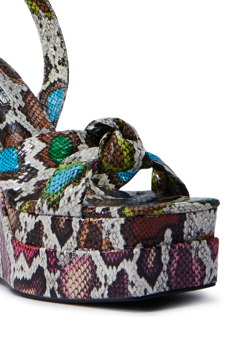 Close-up of an AZALEA WANG CHARMANDER MULTISNAKE WEDGE SANDAL with colorful snakeskin leather. The design features intertwined straps and a platform sole, showcasing green, blue, brown, and beige in a snake-like motif.