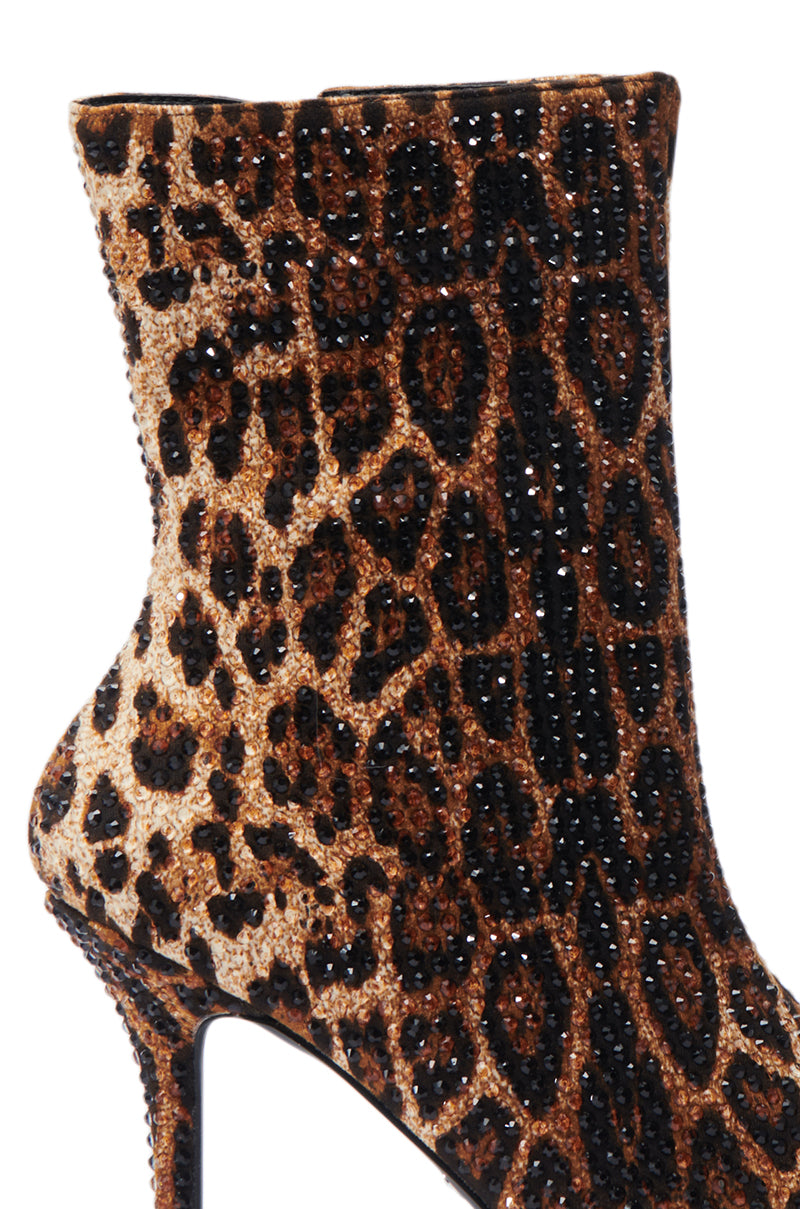 A close-up of the AZALEA WANG CHAUNDRA Leopard Embellished Stiletto Bootie showcases a luxurious style with its shiny, textured material and mixed shades of brown and black leopard print spots, making it ideal for statement-makers. 6
