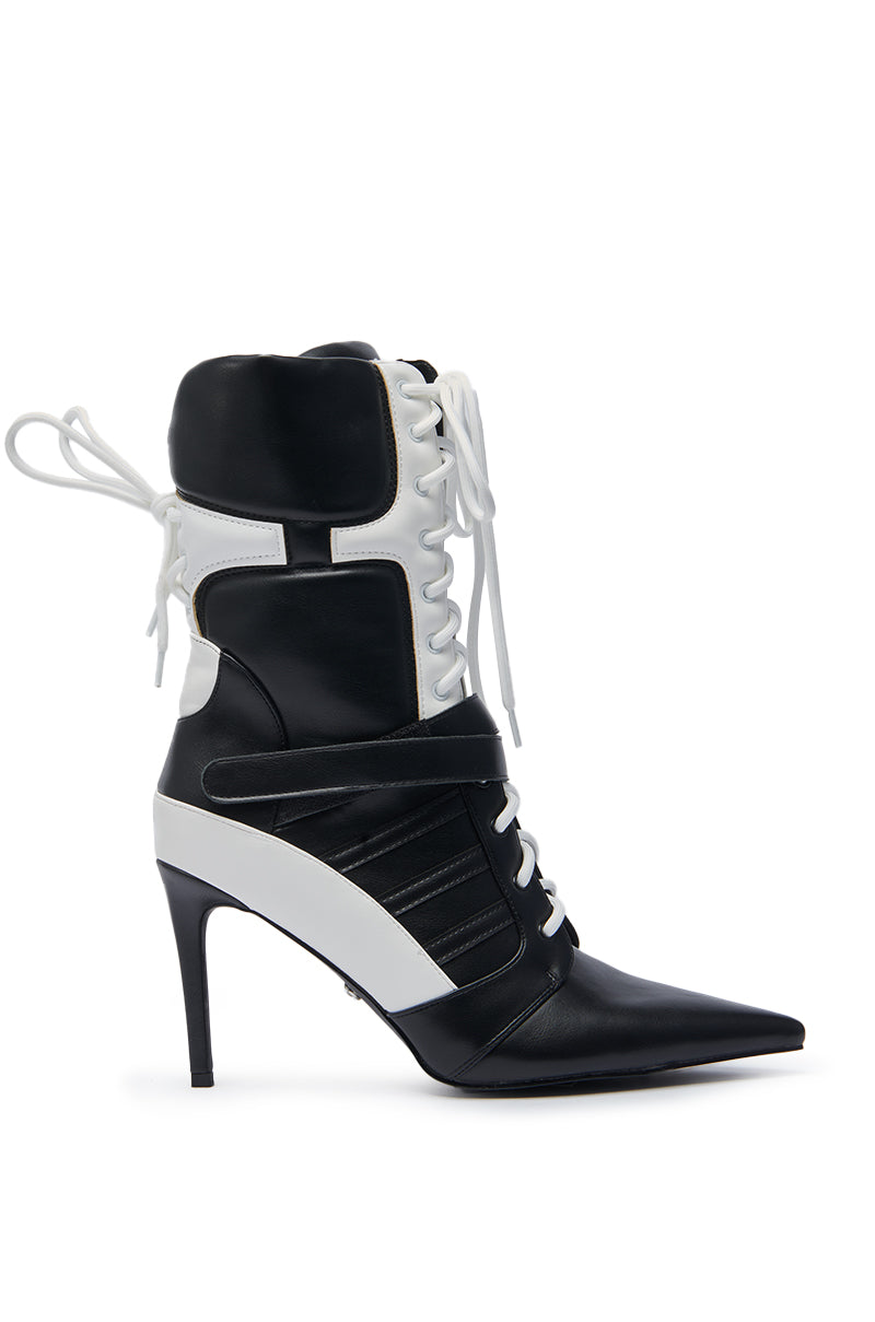 The AZALEA WANG CHAUSIKU BLACK SPORTY BOOTIE is a faux leather ankle boot with black and white color blocking, a stiletto heel, pointed toe, lace-up front, strap detail, and padded ankle sections for comfort.
